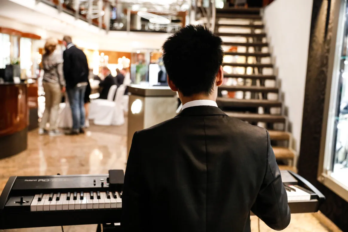 Jerry Lu spielt Klavier bei einem exklusiven Dinnerabend.
